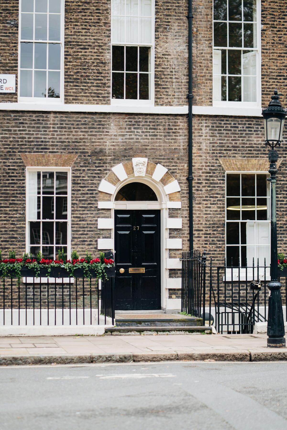 A black Georgian door under a fanlight